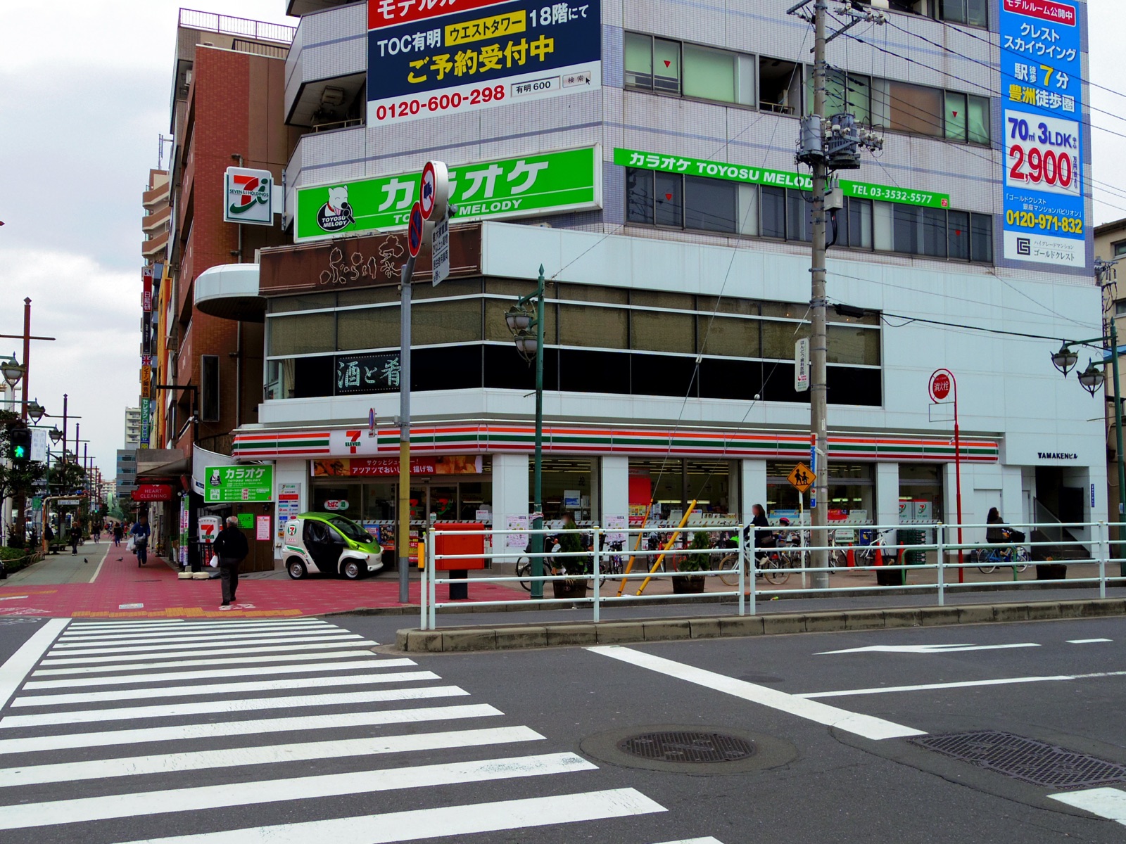 Devanture d'un 7-Eleven à Toyosu, Tokyo, avec l'enseigne rayée rouge, vert et orange