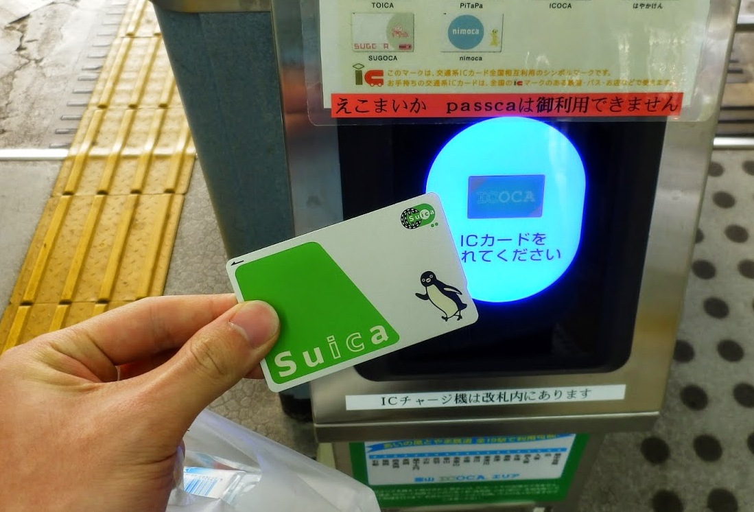 Une carte IC Suica en train d'être validée sur un lecteur de portique en gare